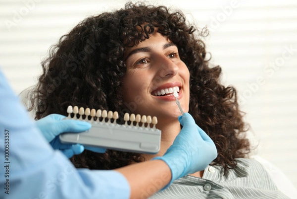 Obraz Doctor checking young woman's teeth color in clinic, closeup. Dental veneers