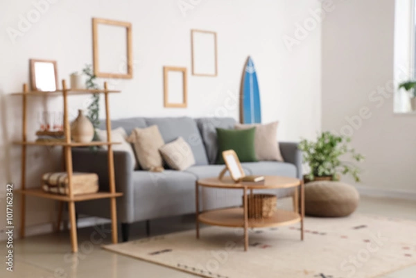 Fototapeta Modern comfortable interior of living room with soft sofa and table, blurred view