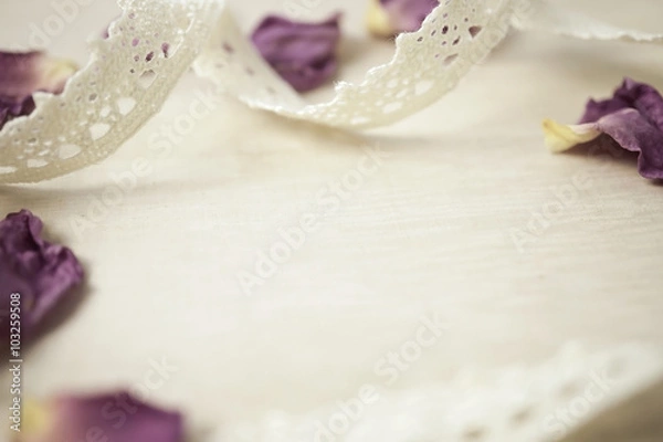 Fototapeta lace and dried rose petals on wooden background in vintage style
