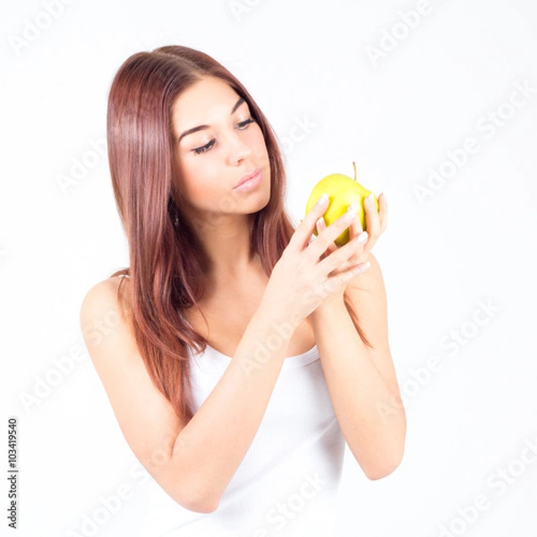 Fototapeta Beautiful woman looking at apple in her hands. Healthy lifestyle.