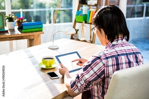 Fototapeta Over shoulder view of casual man using tablet