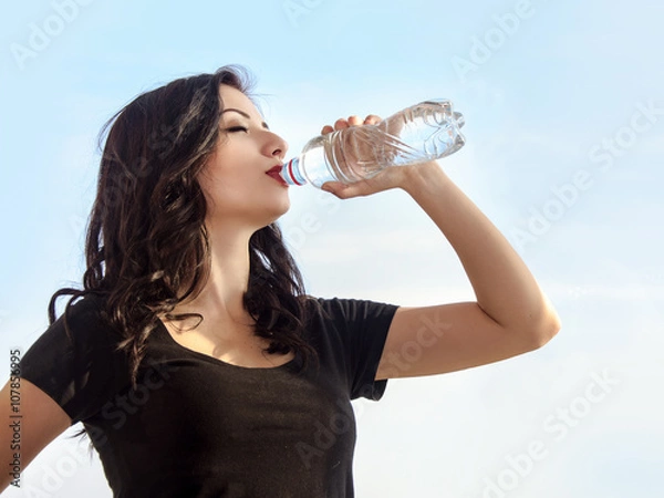 Fototapeta Girl drinking water from a bottle