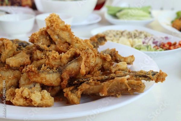 Fototapeta Complementing fish recipe - deep fried fish served with spices s