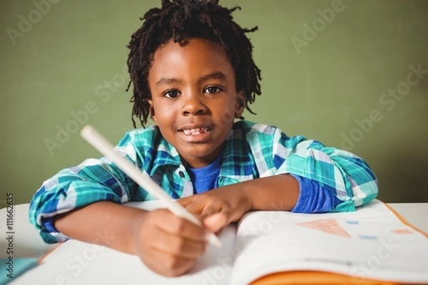 Fototapeta Boy writing in his notebook