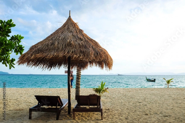 Fototapeta Wooden sun loungers stand on the Andaman Sea coast under dramati