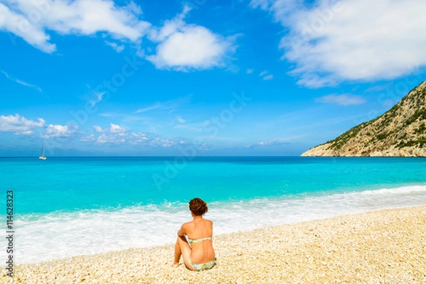 Fototapeta Young woman sitting on beautiful Myrtos beach on Kefalonia island, Greece