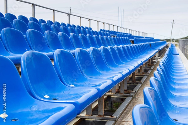 Fototapeta Empty plastic blue chairs at stadium in a row