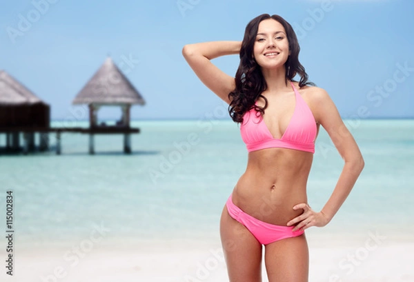 Fototapeta happy young woman in pink bikini swimsuit on beach