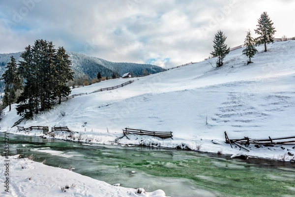 Fototapeta river through the village in winter