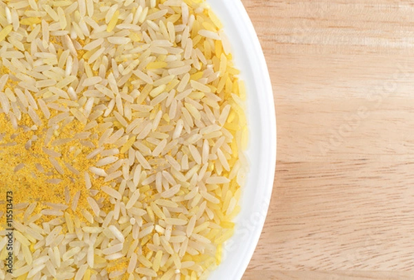 Fototapeta Saffron yellow rice on a white plate and table top.