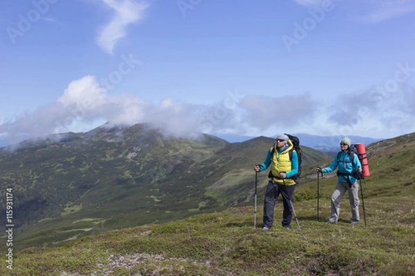 Fototapeta Summer hiking in the mountains with a backpack .