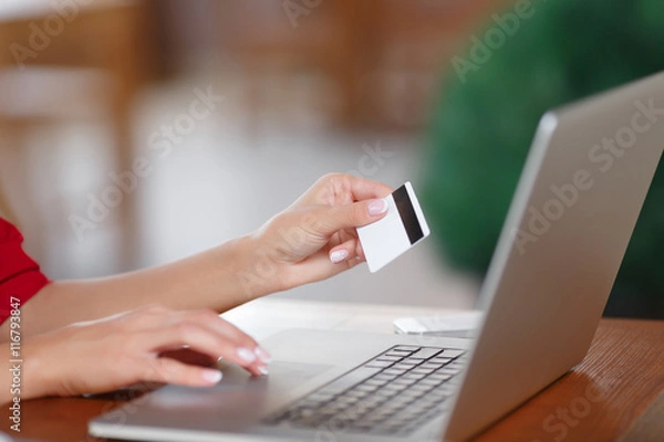 Fototapeta Hands holding credit card and using laptop