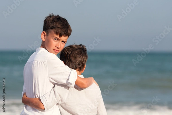 Fototapeta Portrait of happy brothers in white shirts on background of sea