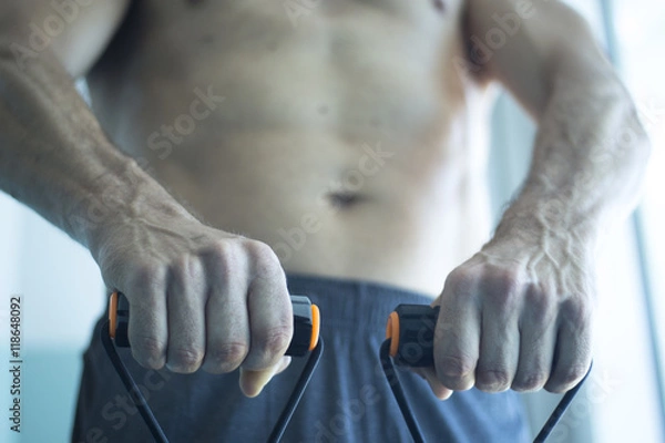 Fototapeta Man exercising with exercise bands