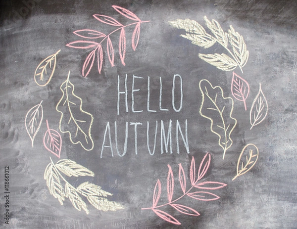 Fototapeta Chalk pattern of hello autumn inside autumn leaves on slate