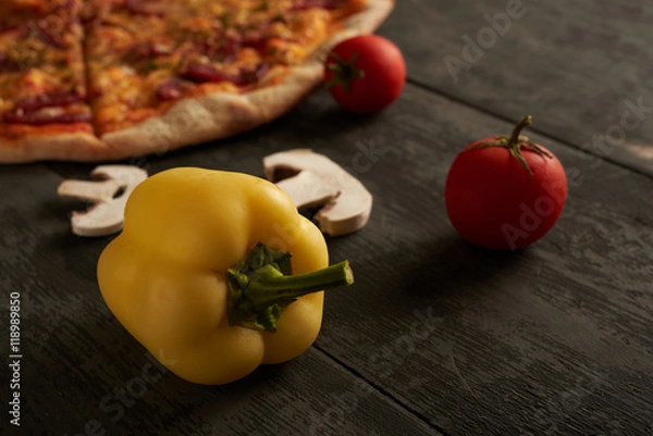 Fototapeta yellow peppers and pizza in the background on the table