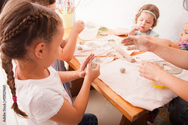 Fototapeta Happy children are engaged with modeling clay