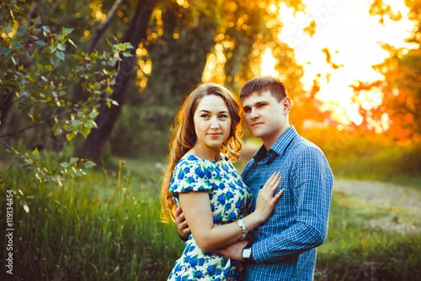 Fototapeta Loving couple embracing sitting in the woods.