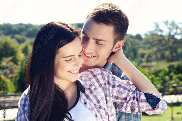 Fototapeta Portrait of happy young couple looking at each other.