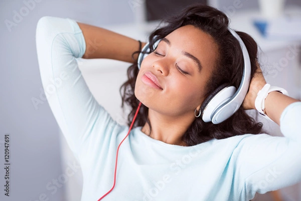 Fototapeta Delighted positive woman listening to music