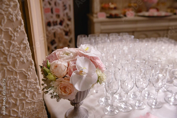 Fototapeta Light bouquet of pink flowers stands in a vase behind empty cham