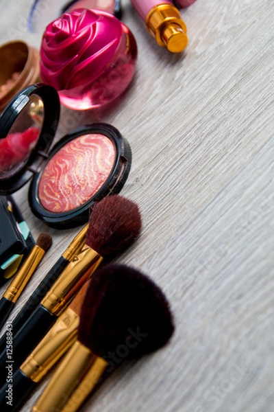 Fototapeta Set of decorative cosmetics and brushes on grey wooden background. Various makeup products. Top view, frame. Copy space.