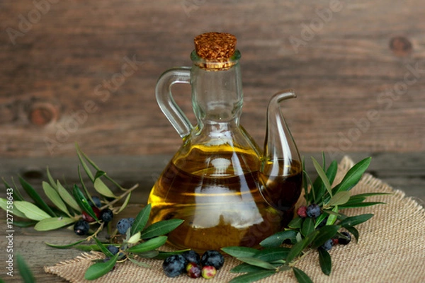 Fototapeta olives and olive oil on a wooden surface