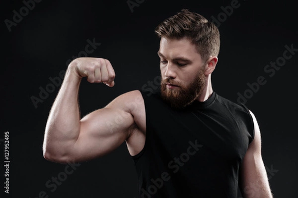 Obraz Fitness man demonstrates bicep