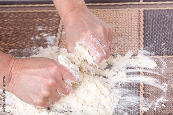 Fototapeta Male hands making dough.