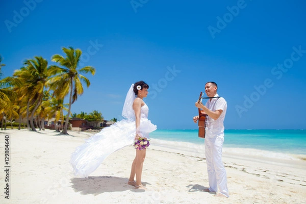 Fototapeta Groom playing the guitar for the bride