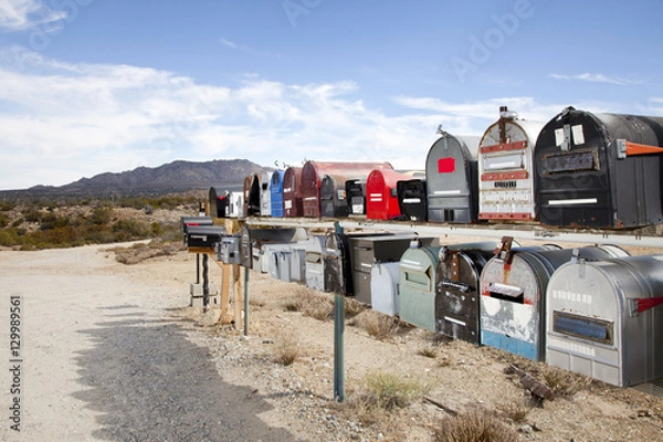 Fototapeta Rows of mailboxes in desert with mountains in background