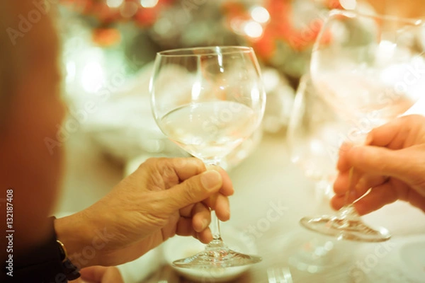 Fototapeta Blurry background luxury dinner party with two men clink glasses