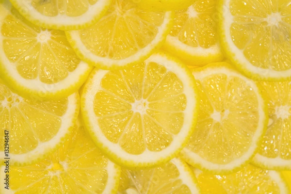 Fototapeta Fresh lemons background. Yellow food background. Juicy slices of lemon. Top view