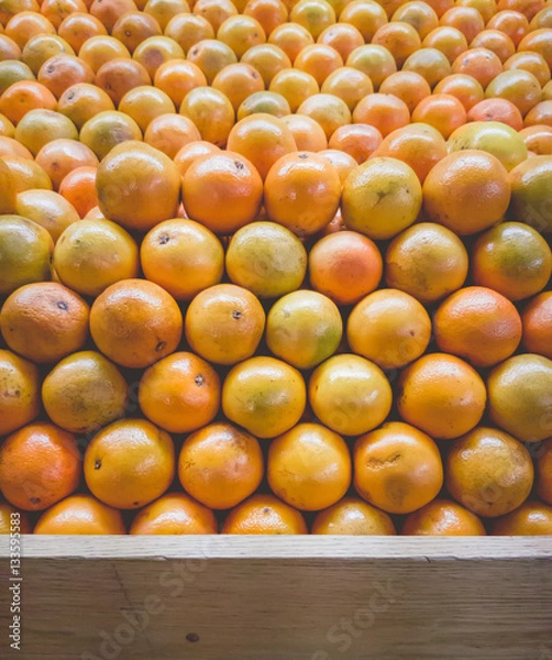 Fototapeta Stack of Oranges on Fruit Shelf Stand with Wood for Copy Space a