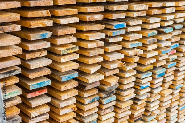 Fototapeta Stack of lumber wood in timber color logs storage, A material for architectural and structural construction or industrial work.