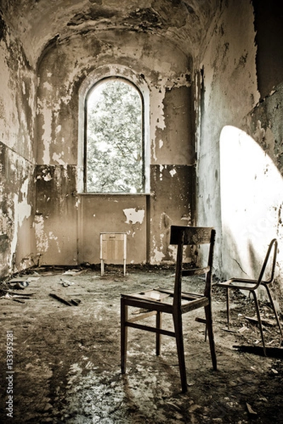 Obraz Old wooden chair abandoned in a ruined building. Picture taken at abandoned psichiatric hospital of Mombello, near to Milan - Italy.