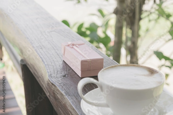 Fototapeta Close up white cup of Coffee, latte on the wooden table with pink gift.