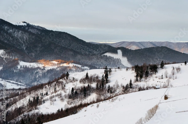 Fototapeta Winter mountain view at dawn wooden fence in snow, blue, green t