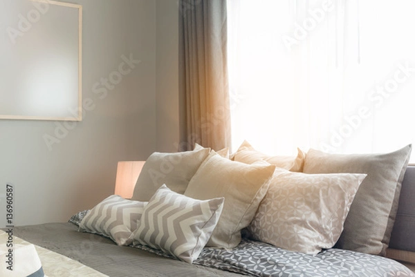 Fototapeta set of pillows on bed in cozy bedroom