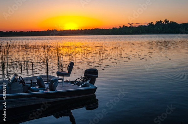 Fototapeta Fishing boat on tranquil lake at sunset in Minnesota