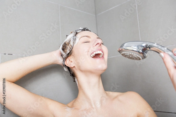 Fototapeta Woman in shower washing hair with shampoo