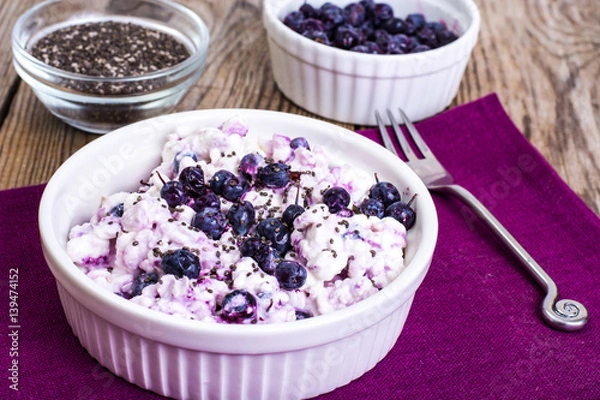 Fototapeta Cottage cheese with berries and chia seeds in white bowl