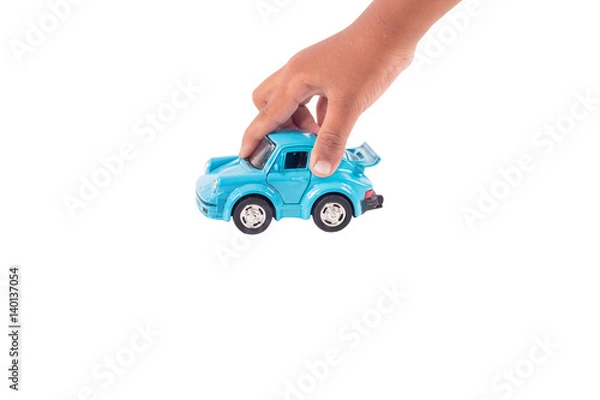 Fototapeta Hand little boy play toy blue car on road  isolate