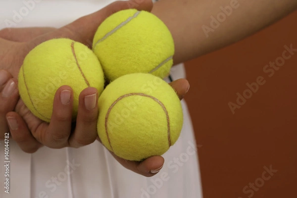 Fototapeta A female tennis player holding balls in her hand