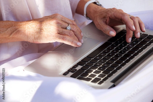 Fototapeta older woman hands typing on laptop computer