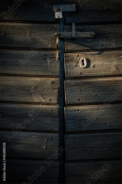 Fototapeta Old lock on barn door in afternoon light