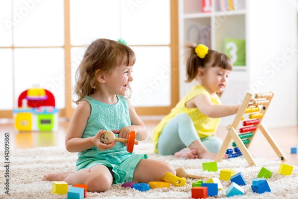 Obraz Little kids playing with abacus and constructor toys in kindergarten, playschool or daycare center