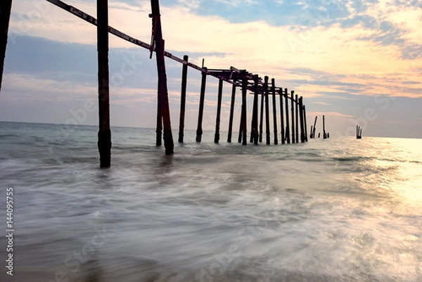 Fototapeta Wooded bridge in the port between sunrise.