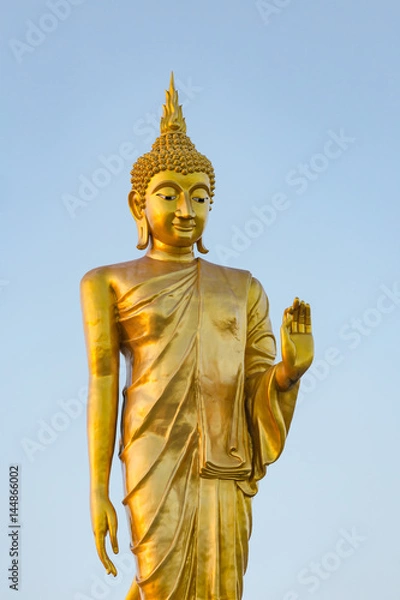 Fototapeta The standing buddha statue on blue sky, located in Chanthaburi, Thailand.