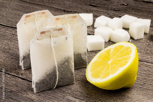 Fototapeta tea bags,sugar and lemon on the wooden table